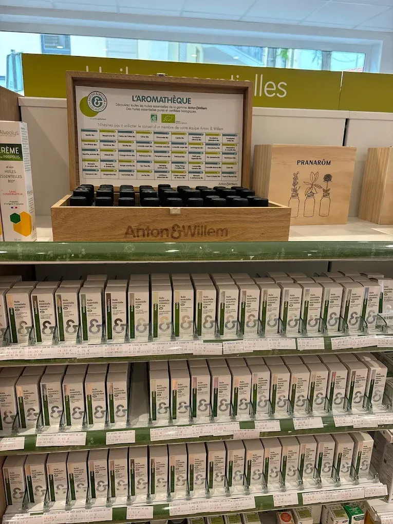 Présentoir de produits en boîte sur une étagère, avec un panneau et des rangées d'articles verts et blancs en dessous.
