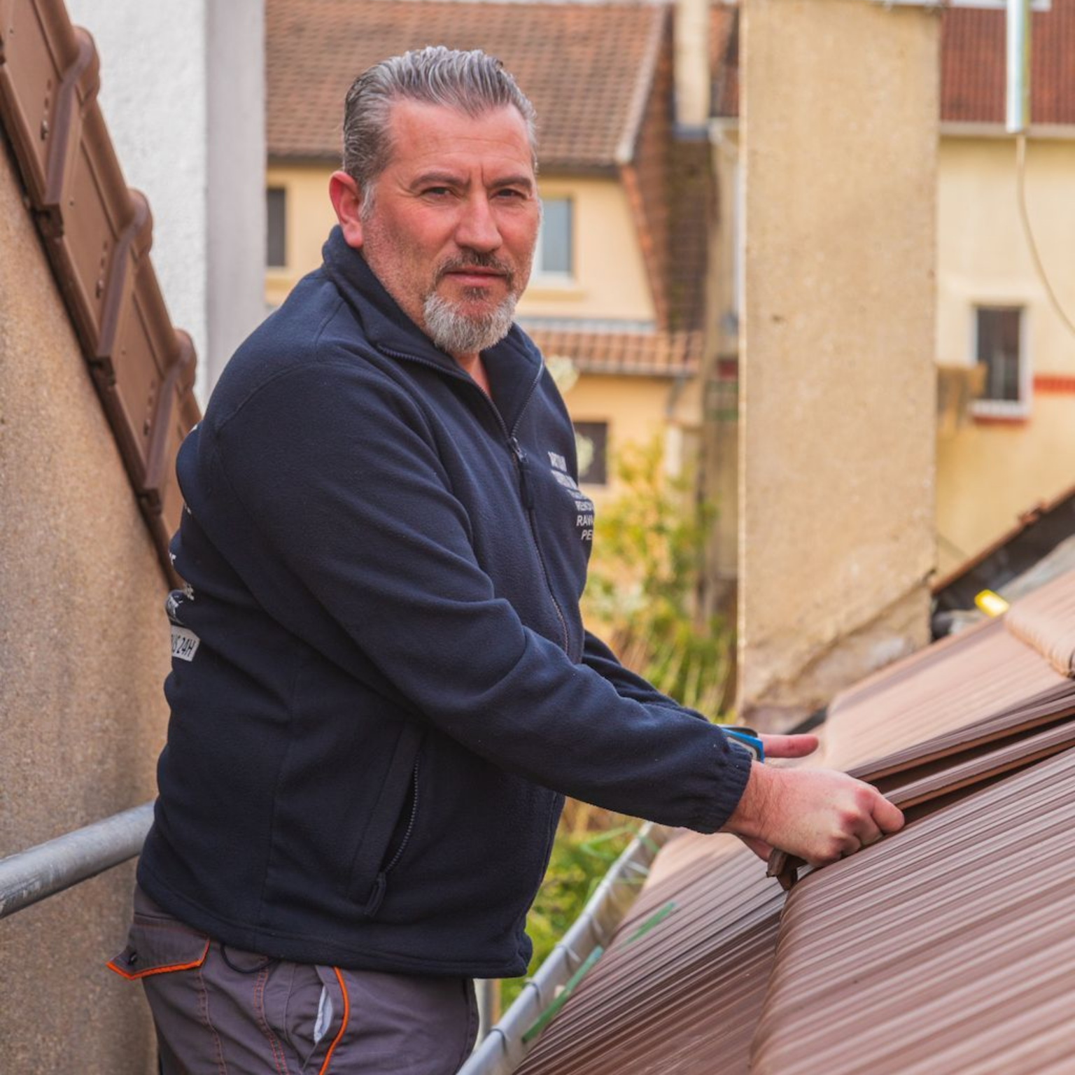 Professionnel tenant les tuiles en terre cuite.