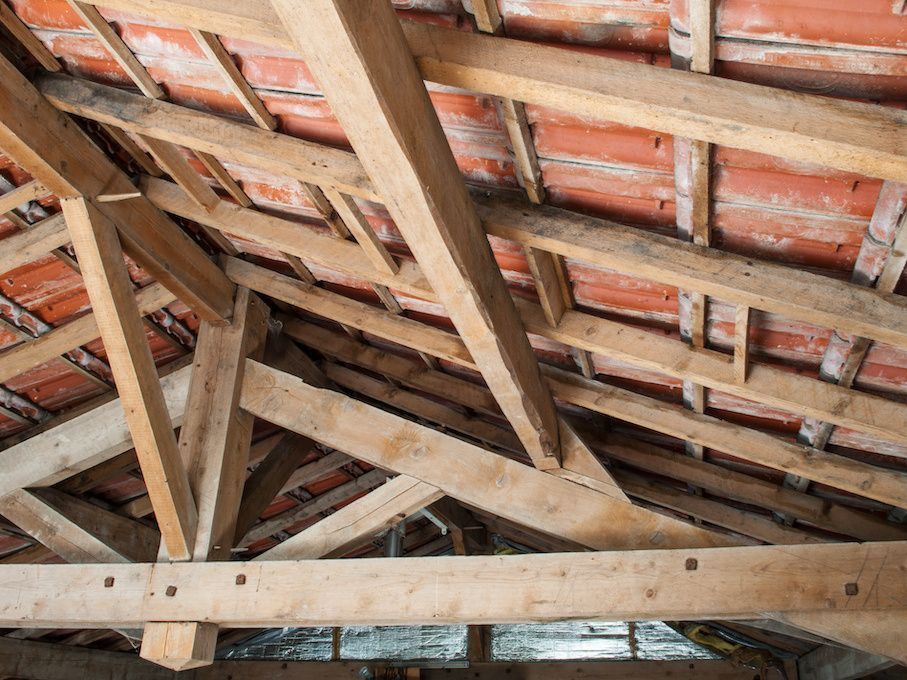 Charpente en bois avec les tuiles de la toiture visibles.