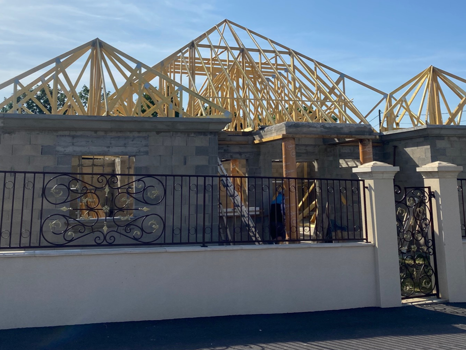 Maison en construction avec sa charpente en bois.