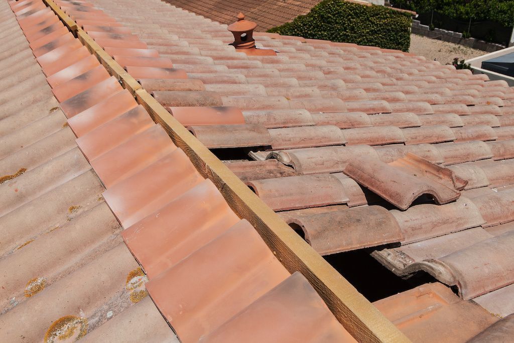 Gros plan sur une partie de toiture en tuiles en travaux.