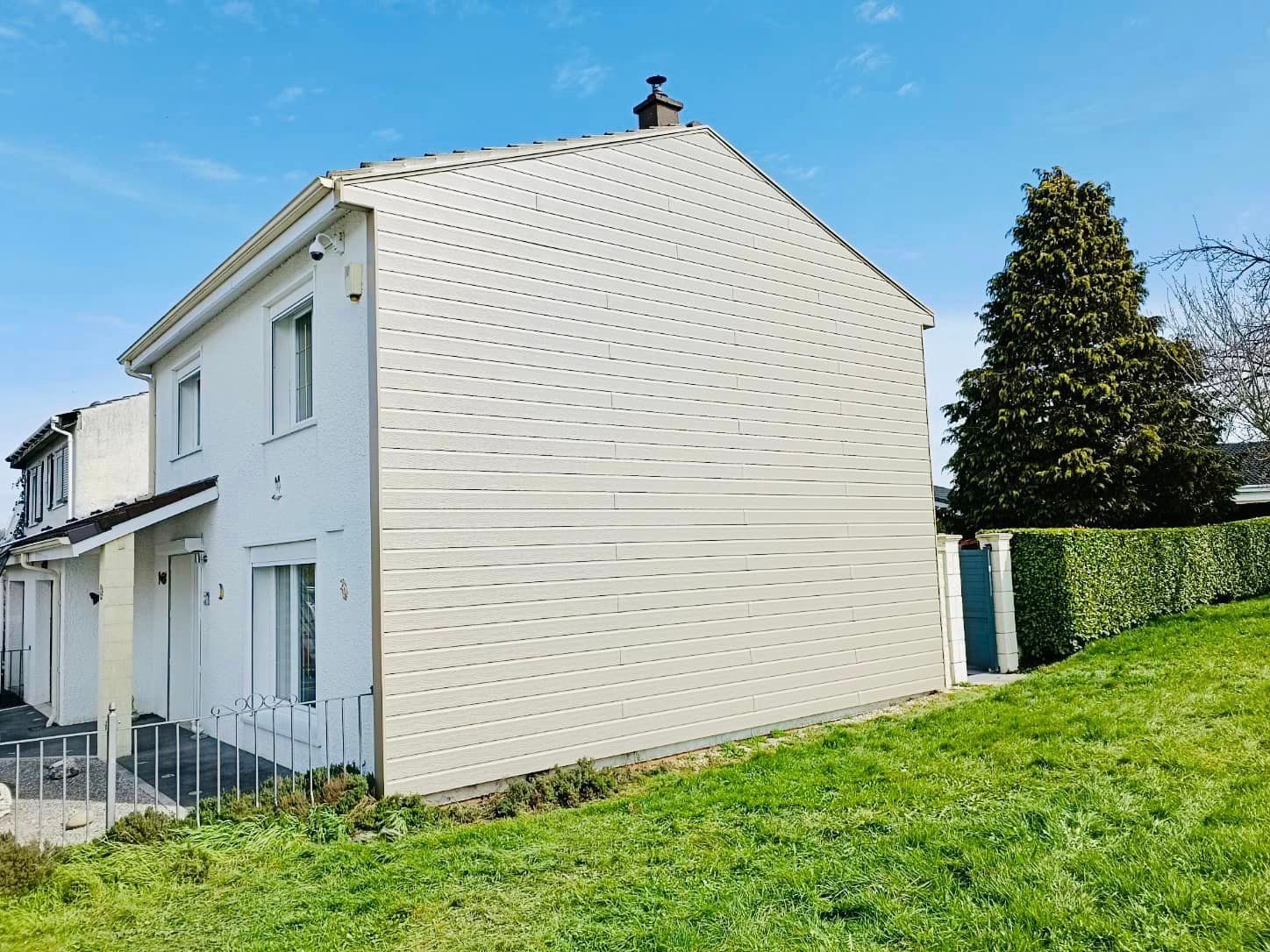 Une maison avec un bardage blanc