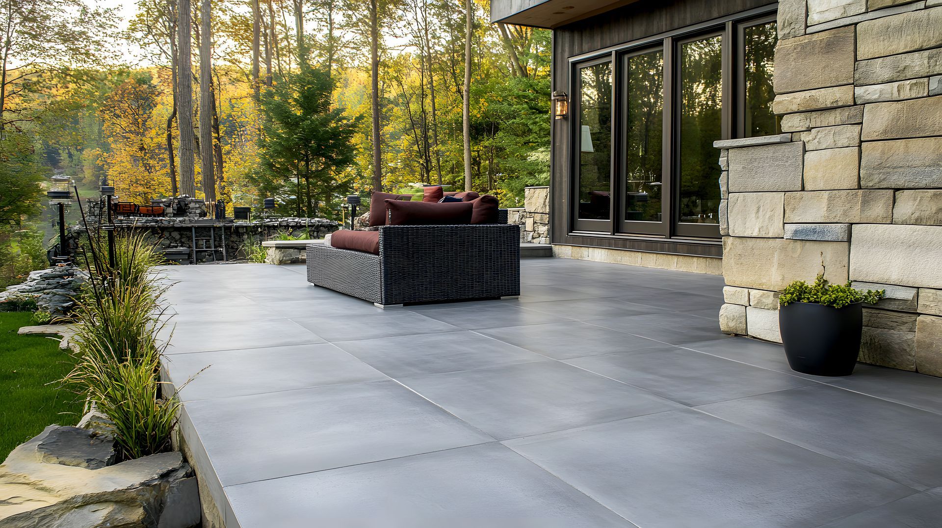 Eine Terrasse mit einem Sofa und einem Stuhl vor einem Haus.