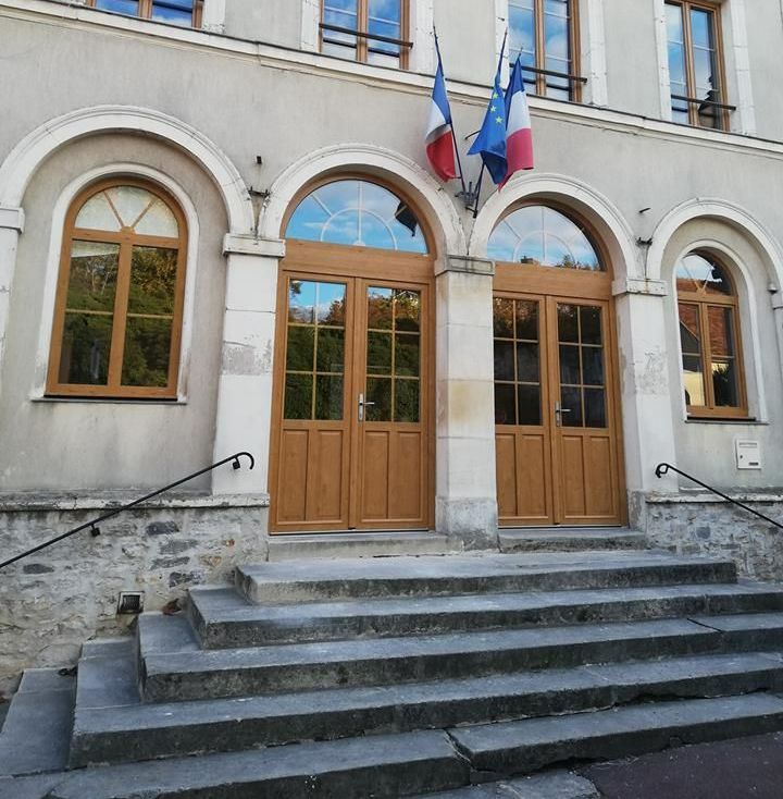Façade d'une maison avec une porte d'entrée et des fenêtres marron