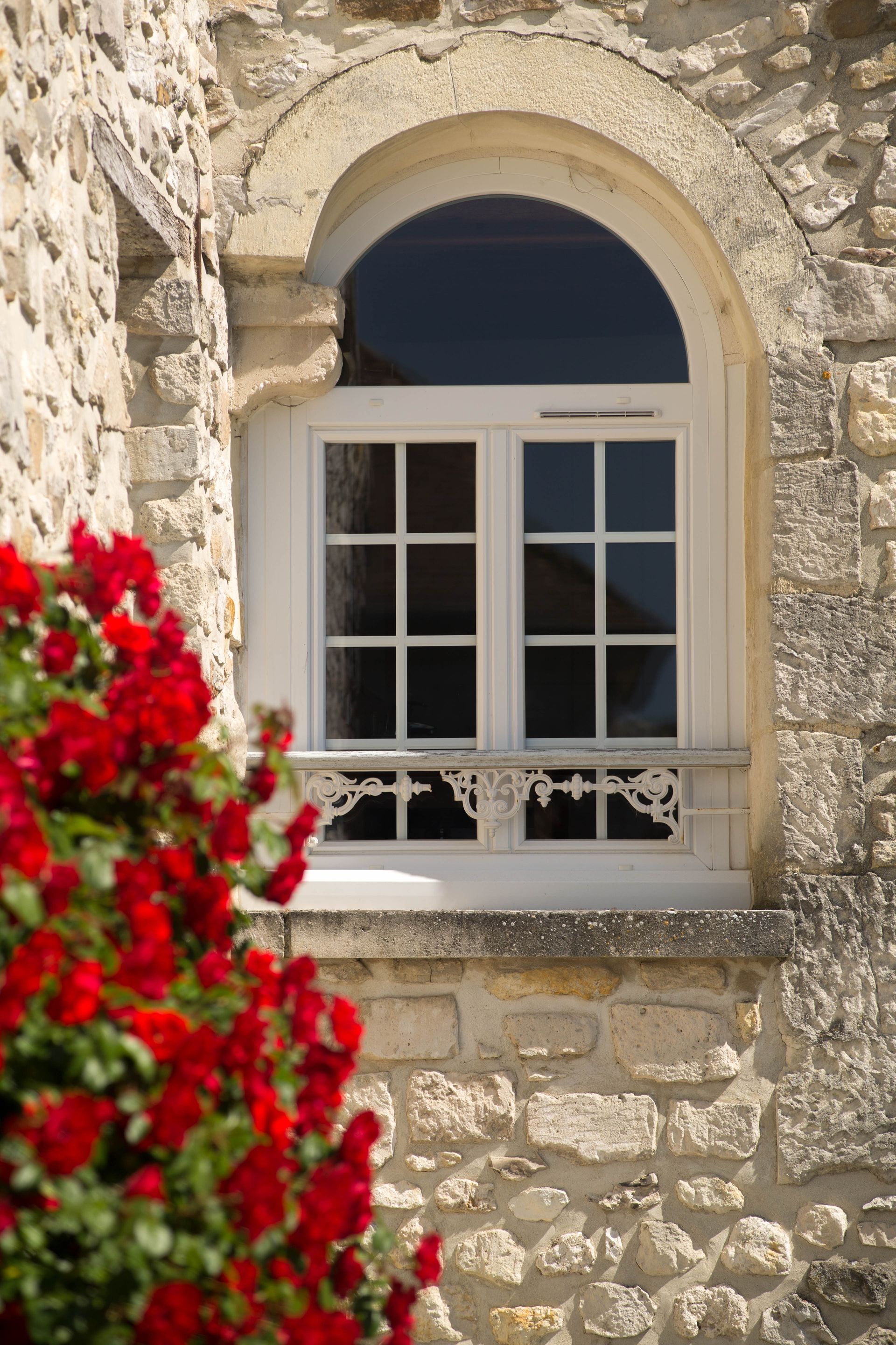 Fenêtre arrondie à carreaux avec des fleurs