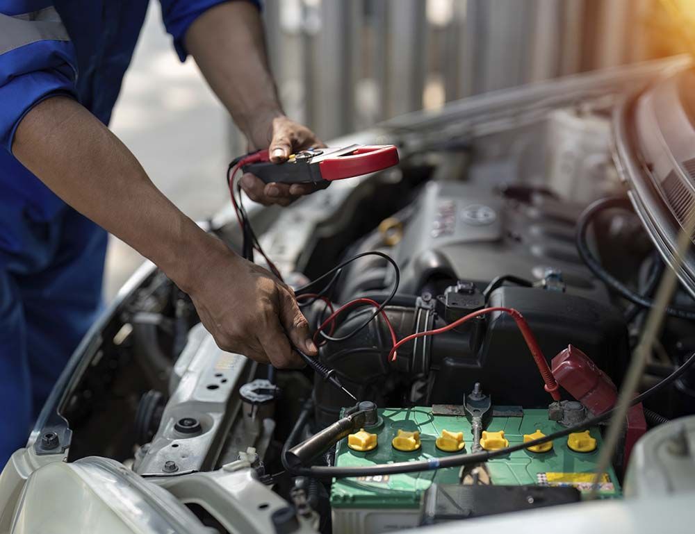 Un hombre está trabajando en el motor de un coche.