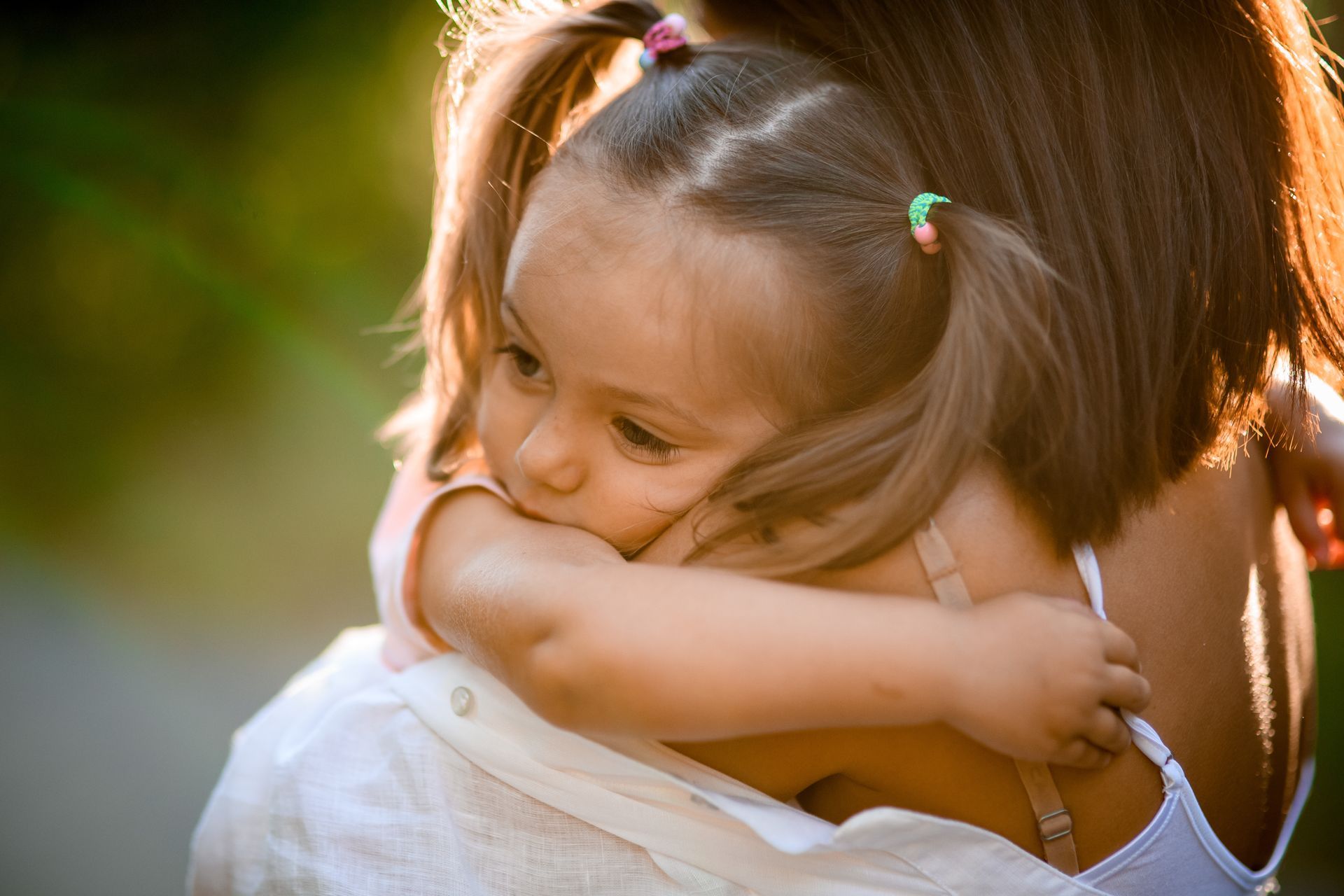 Petite fille dans les bras d'une femme