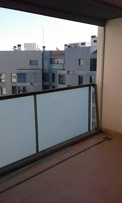 Un balcón vacío con vista a una ciudad.