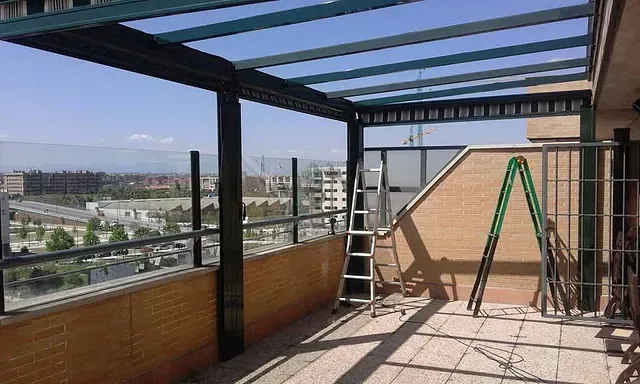Una escalera está sentada en un balcón con vista a una ciudad.