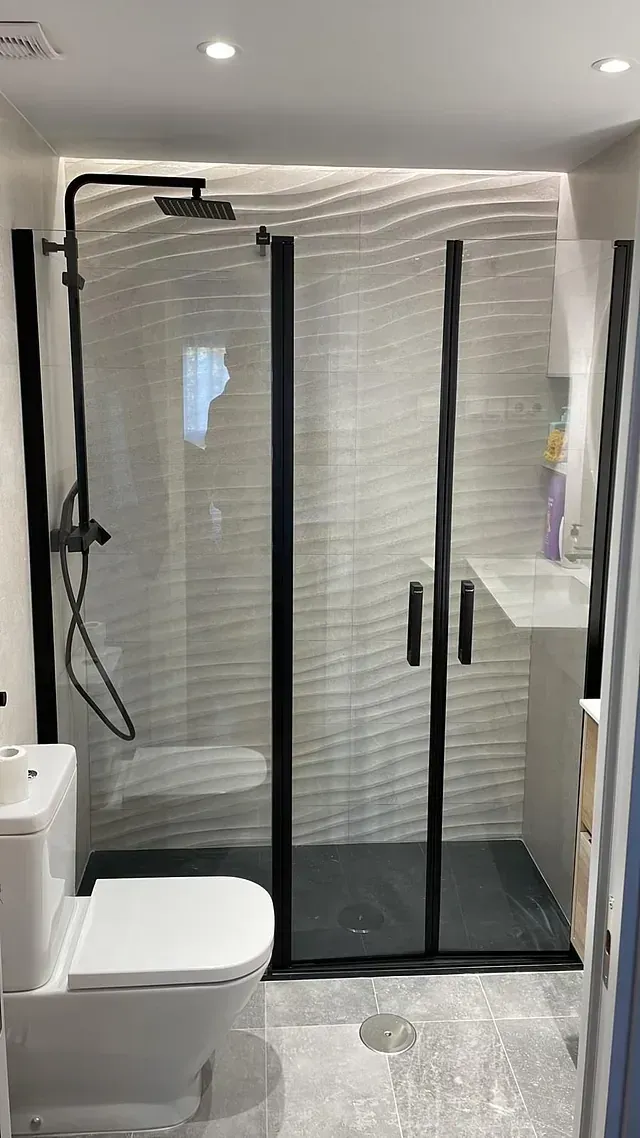 Un baño con inodoro, lavabo y ducha.