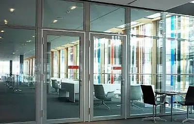 Una habitación con muchas ventanas y sillas.