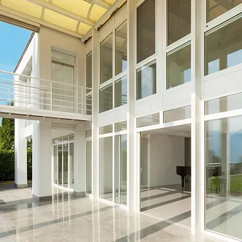 Una habitación grande con muchas ventanas y un piano.