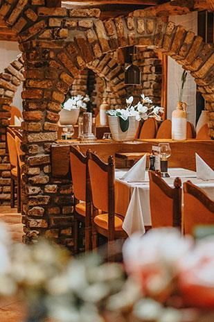 Ein Restaurant mit Tischen und Stühlen und einer Backsteinwand.