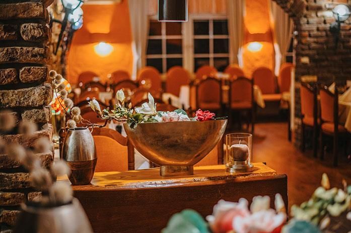 Auf einem Tisch in einem Restaurant steht eine Schale mit Blumen.