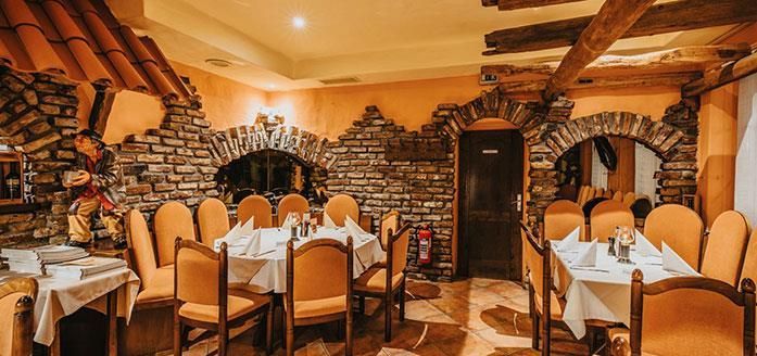 Ein Restaurant mit Tischen und Stühlen und einer Backsteinwand.