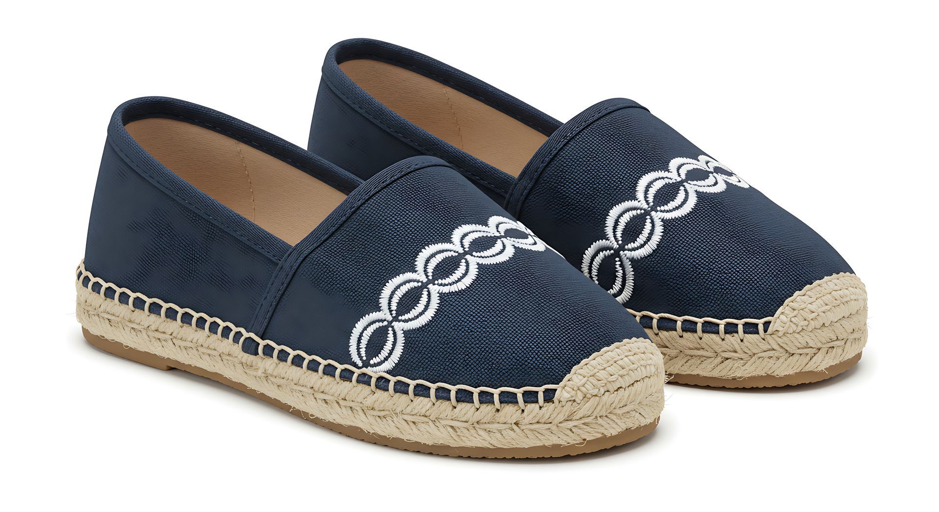 Une paire d'espadrilles bleu marine avec broderies blanches au point de chaînette et semelle en jute tressée.