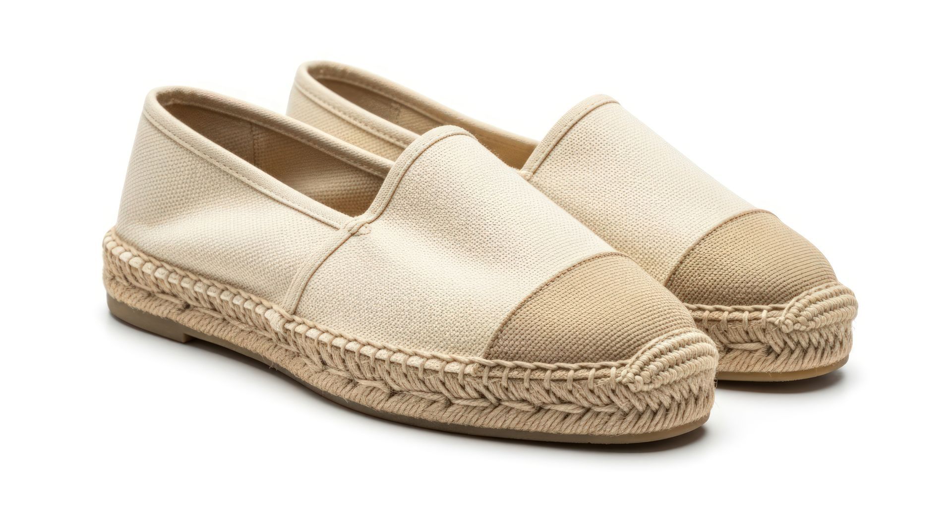 Une paire d'espadrilles beiges en toile, à enfiler, avec des semelles en jute tressé.