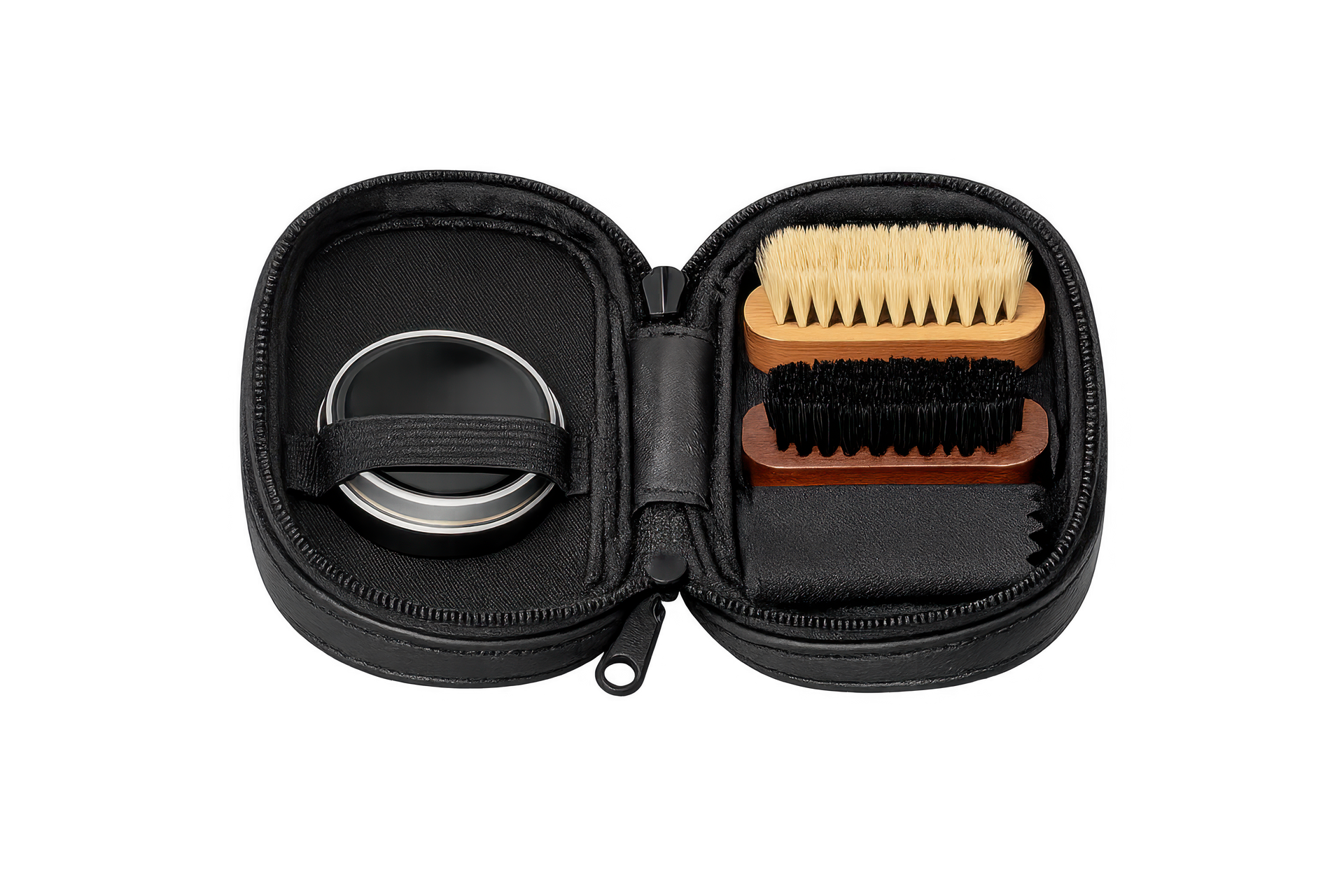 Une petite trousse de transport noire ouverte avec fermeture éclair contenant une boîte de cirage, un chiffon de nettoyage et deux petites brosses à manche en bois.