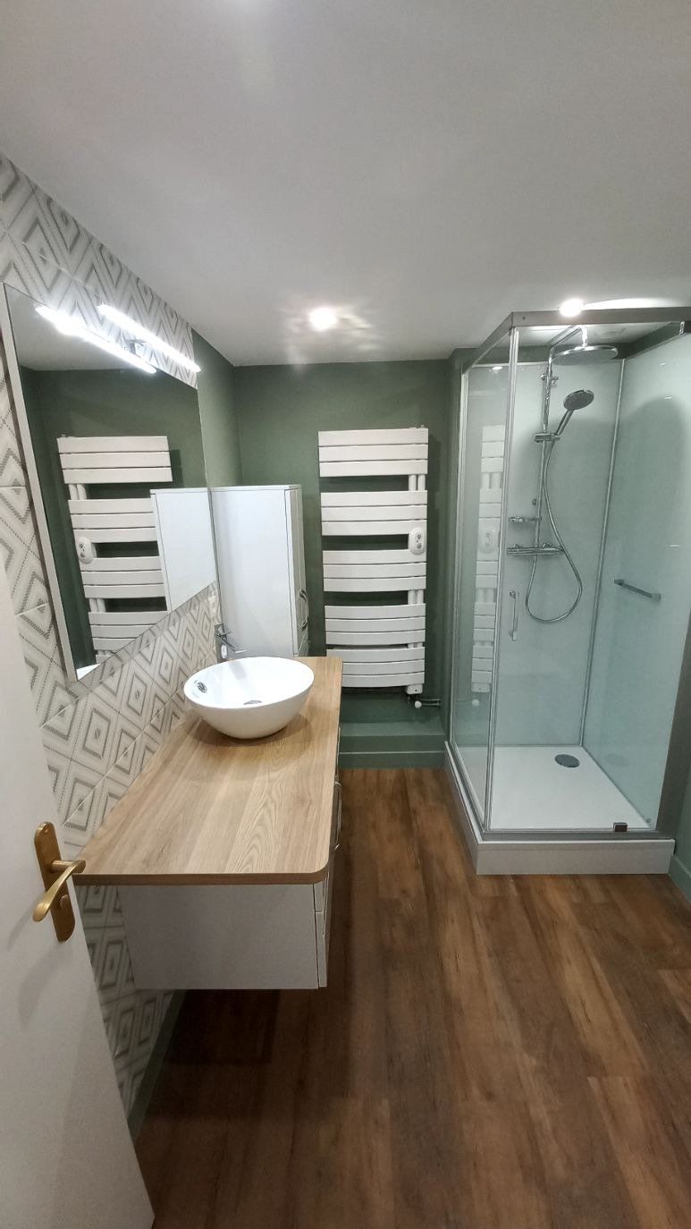 Salle de bains complète avec douche, sèche-serviette et vasque