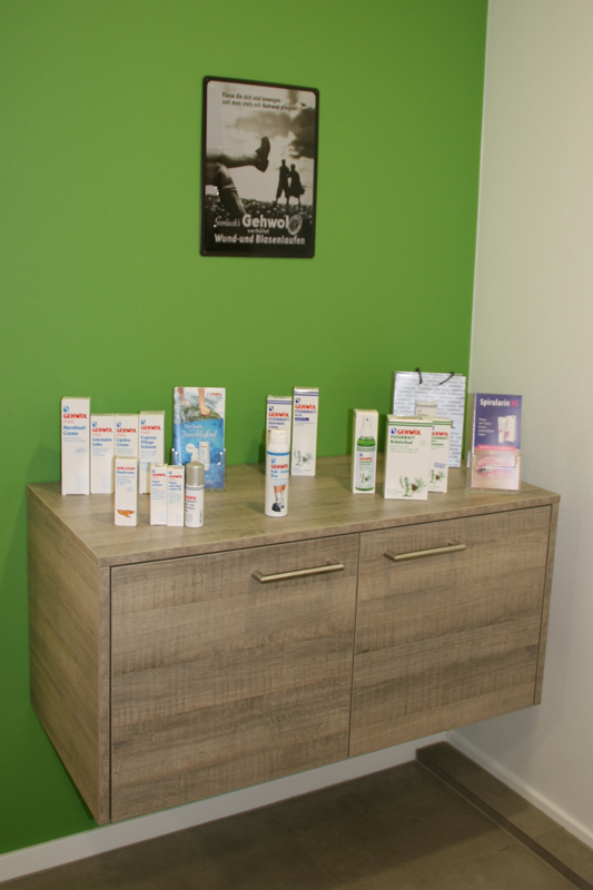 Ein Holzschrank mit einer grünen Wand dahinter