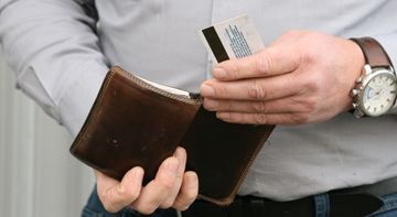 Ein Mann nimmt eine Kreditkarte aus seiner Brieftasche.