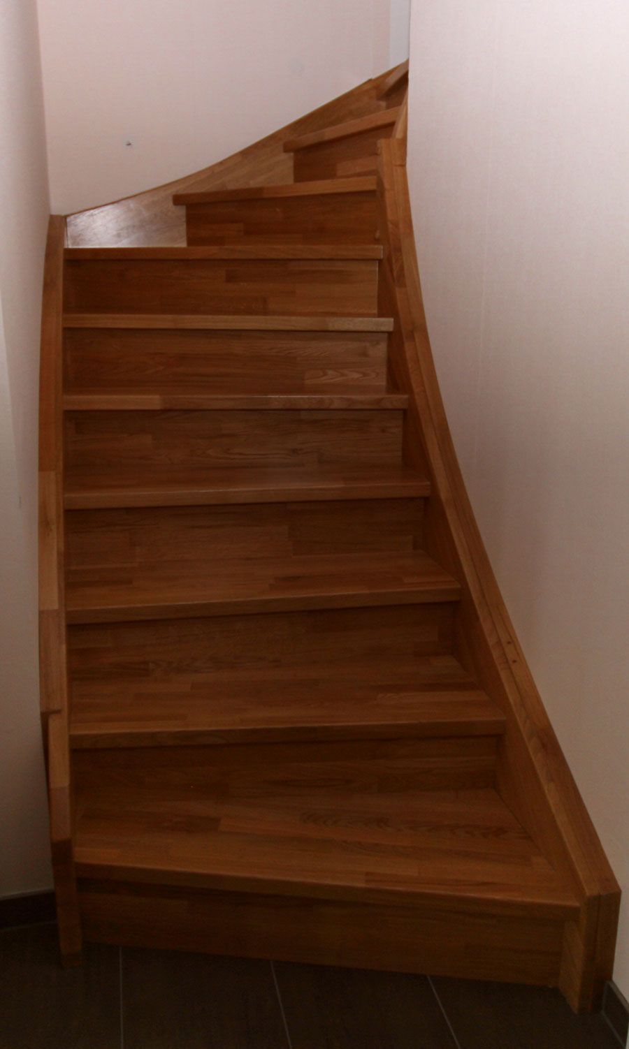 Eine Holztreppe mit einer weißen Wand dahinter