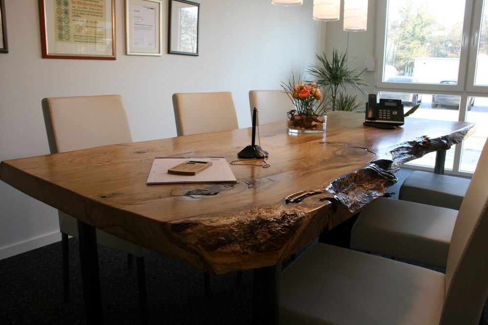 Ein Konferenzraum mit einem großen Holztisch und Stühlen