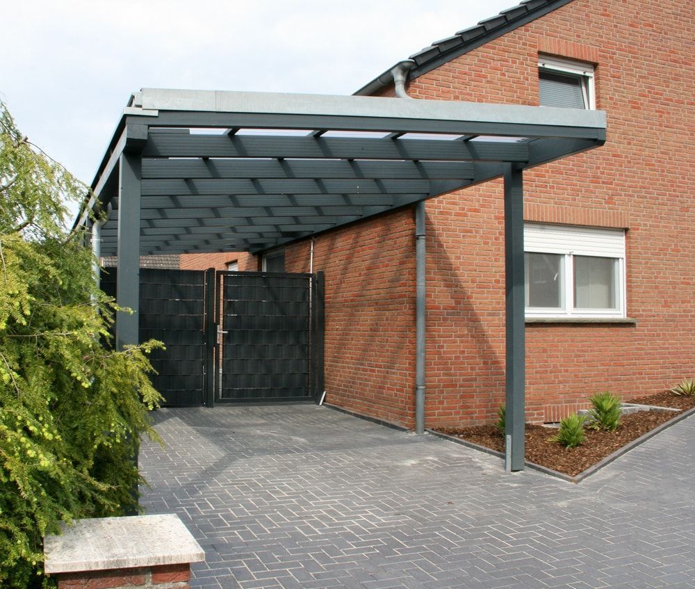 Ein Carport ist an der Seite eines Backsteinhauses angebracht