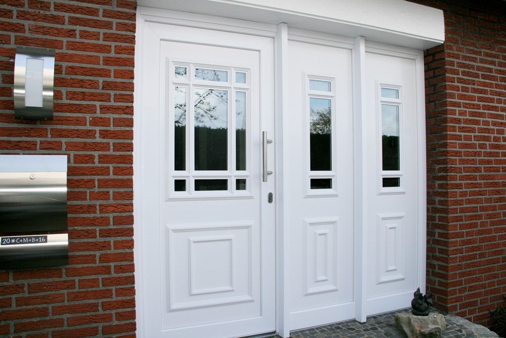 Ein Backsteingebäude mit einer weißen Tür und einem Briefkasten