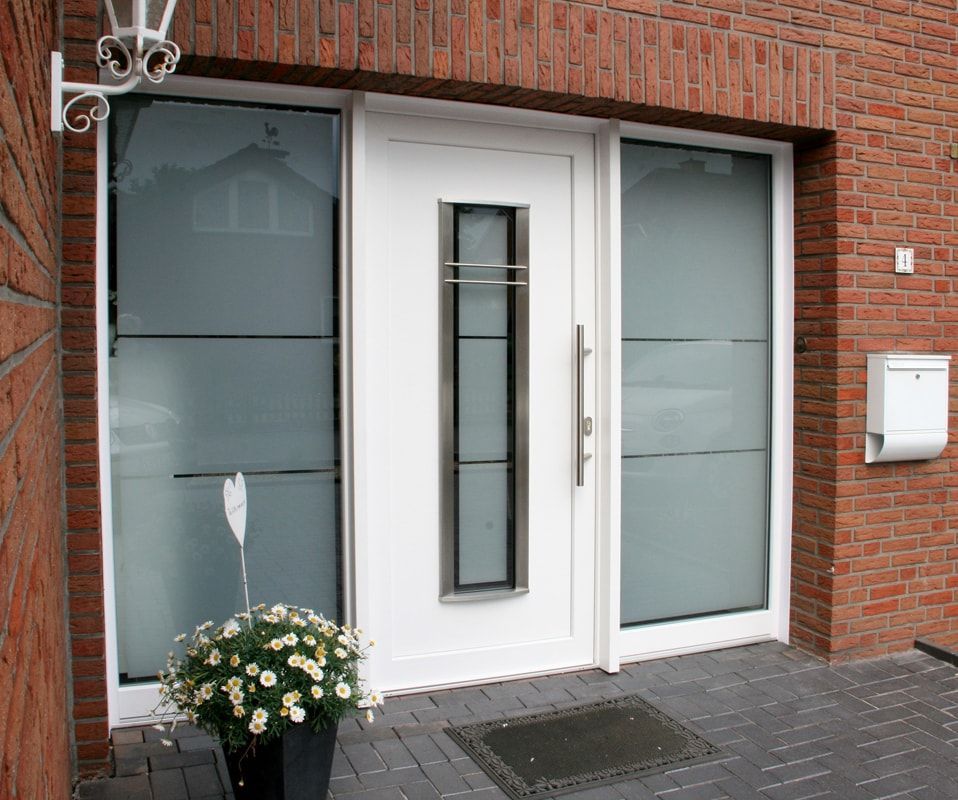 Die Eingangstür eines Backsteingebäudes mit einer weißen Tür