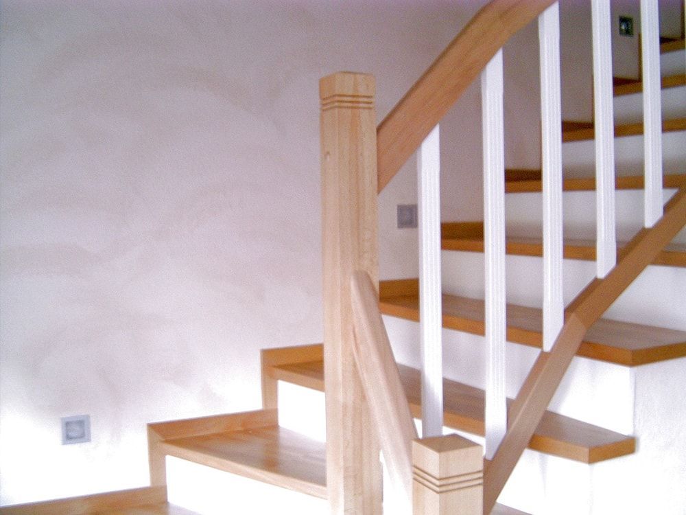 Eine Holztreppe mit einem weißen Geländer