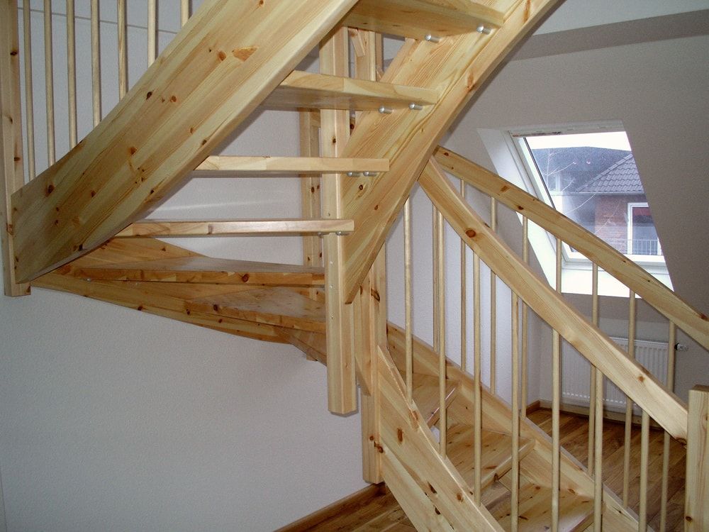 Eine Holztreppe in einem Raum mit einem Fenster