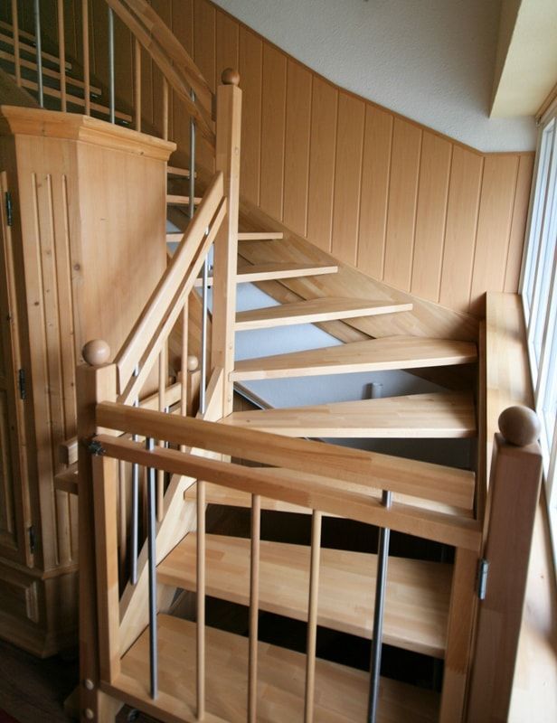 Eine Holztreppe mit einem Metallgeländer in einem Raum