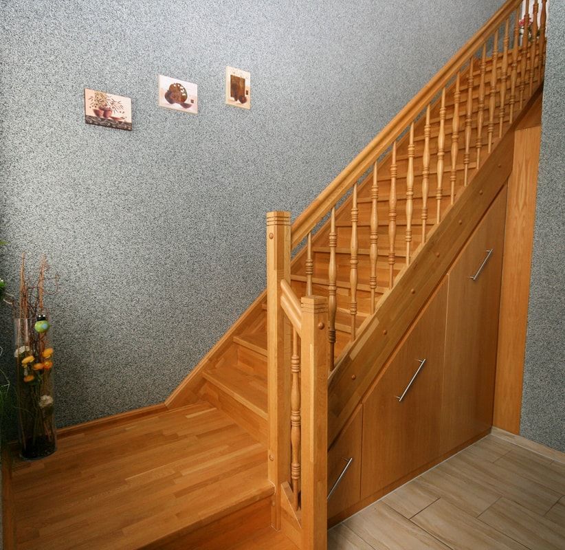 Eine Holztreppe mit einem Metallgeländer in einem Flur