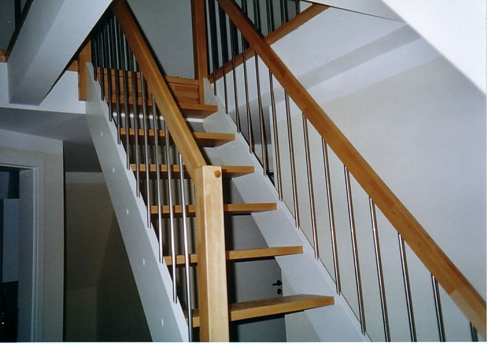 Eine weiße Treppe mit Holzstufen und Metallgeländer