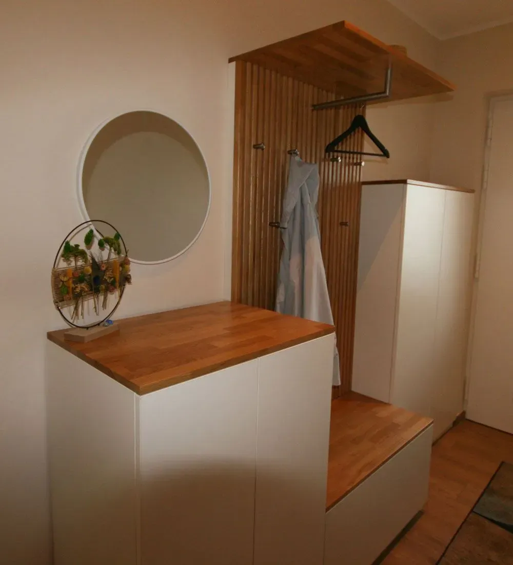 Ein Flur mit Spiegel und Holzbank