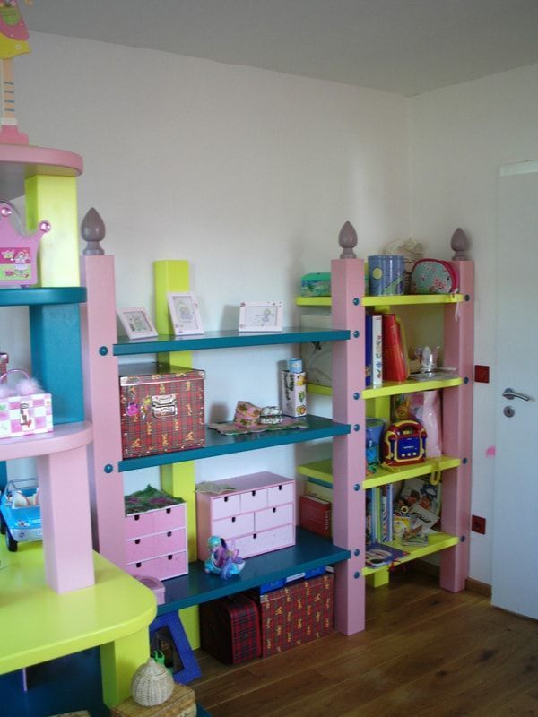 Ein Kinderzimmer mit vielen Regalen und Kisten