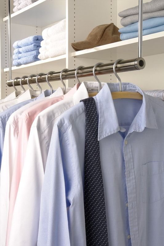 Eine Reihe von Hemden und Krawatten hängen in einem Schrank