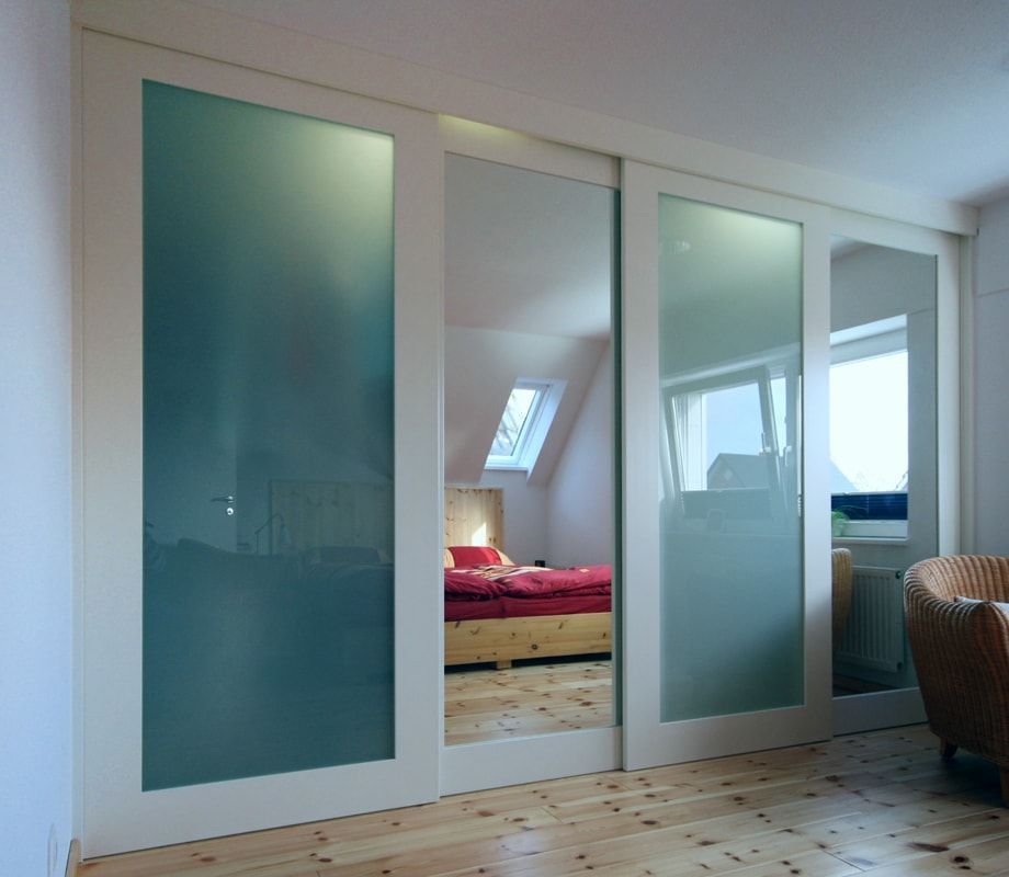 Ein Schlafzimmer mit Glasschiebetüren, die zu einem Bett führen