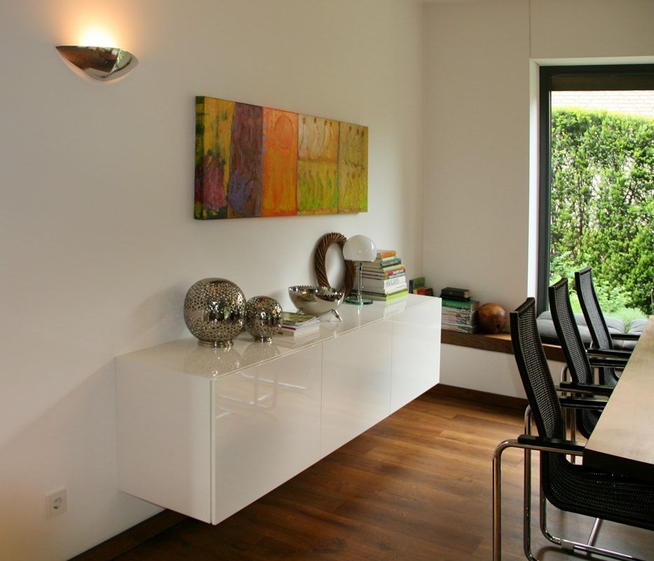 Ein Esszimmer mit Tisch und Stühlen und einem Gemälde an der Wand