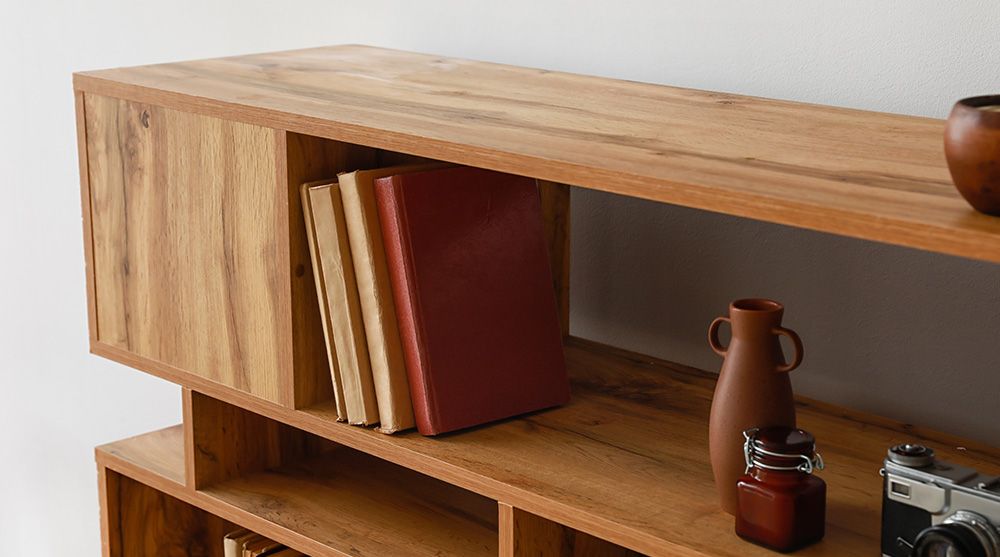 Ein Holzregal mit Büchern, Vasen und einer Kamera darauf.