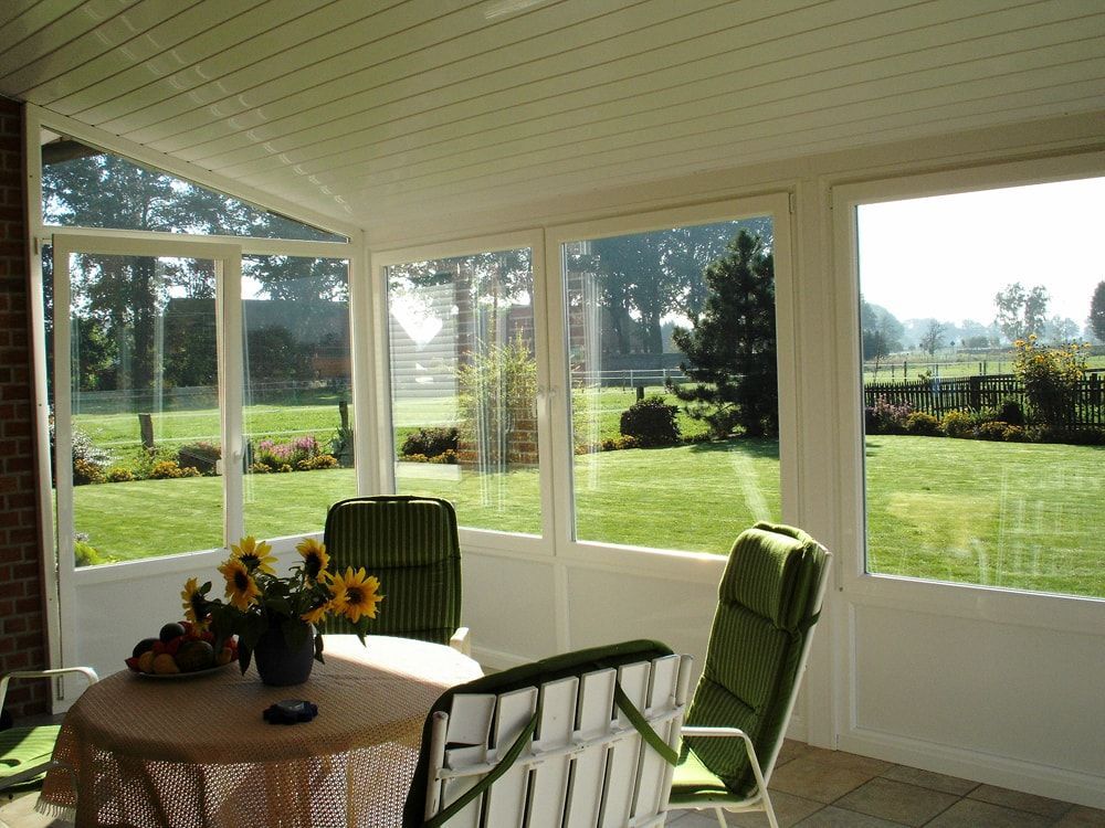 Eine abgeschirmte Veranda mit Tisch und Stühlen