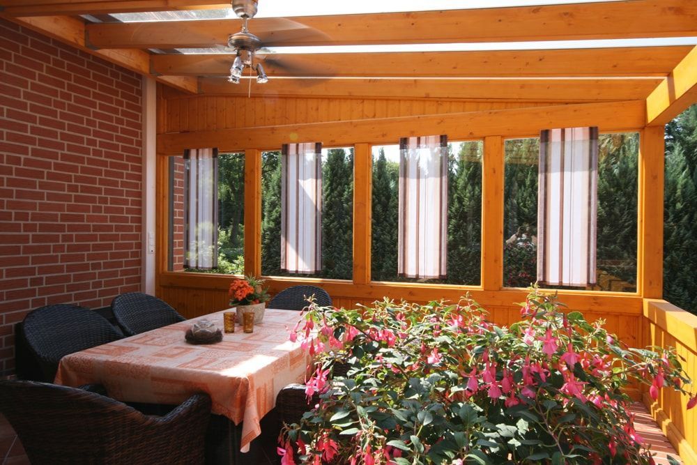 Eine Terrasse mit Tisch und Stühlen und Blumen