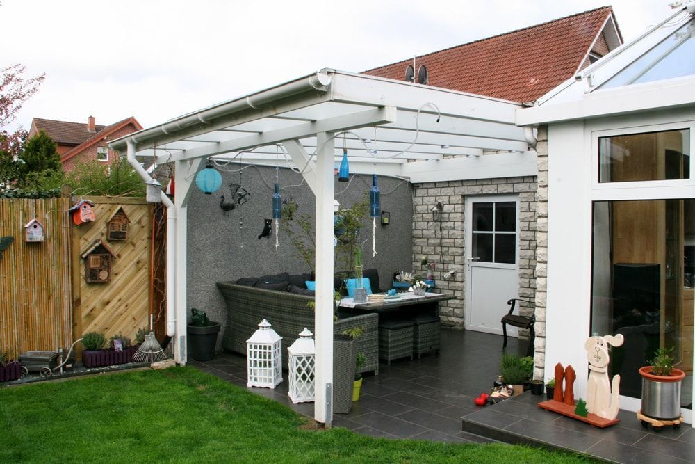 Im Hinterhof eines Hauses steht eine Pergola.