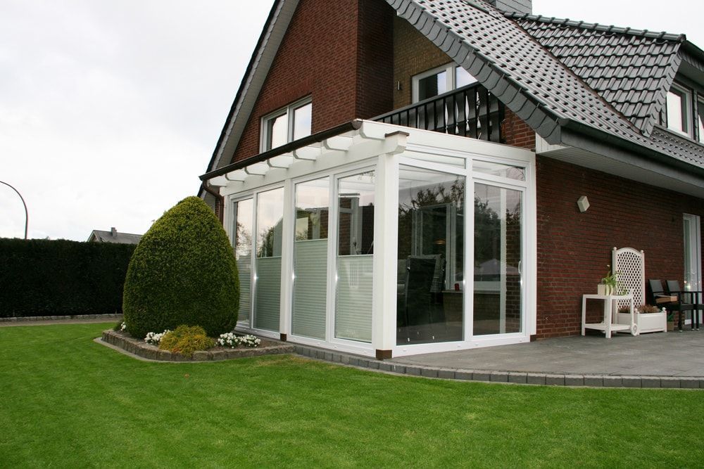 Ein großes Backsteinhaus mit einer großen weißen Veranda