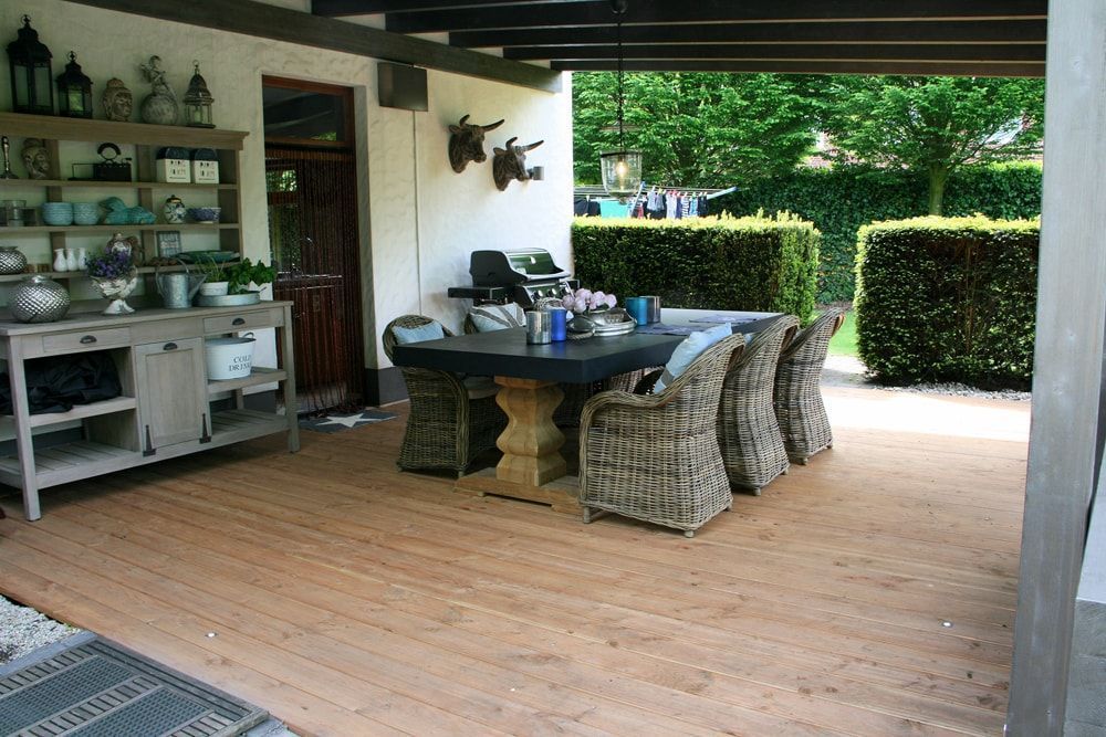 Eine Terrasse mit Tisch und Stühlen unter einem Baldachin