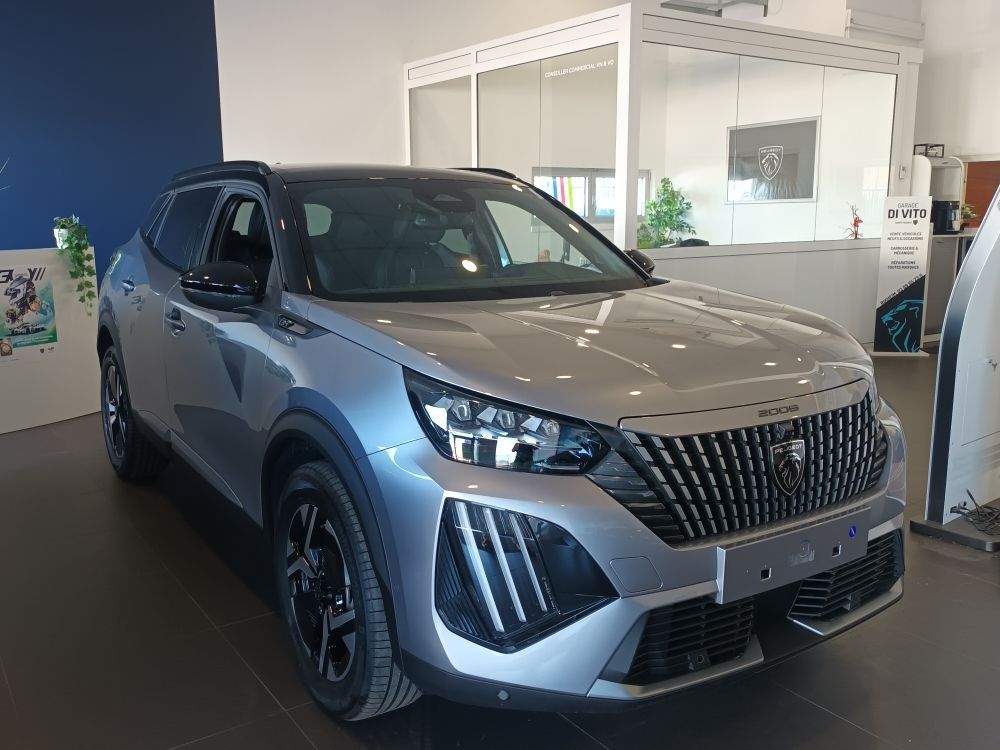 Un SUV Peugeot 3008 argenté est garé dans une salle d'exposition.