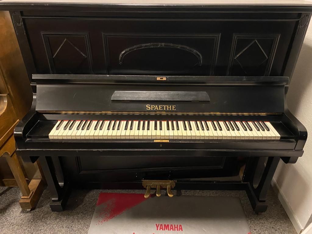 Ein schwarzes Klavier mit einem Yamaha-Logo auf dem Boden