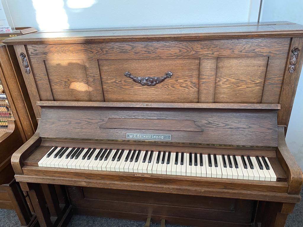 Ein hölzernes Klavier mit weißen Tasten steht auf dem Boden