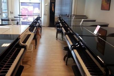 Eine Reihe von Klavieren steht in einem Raum